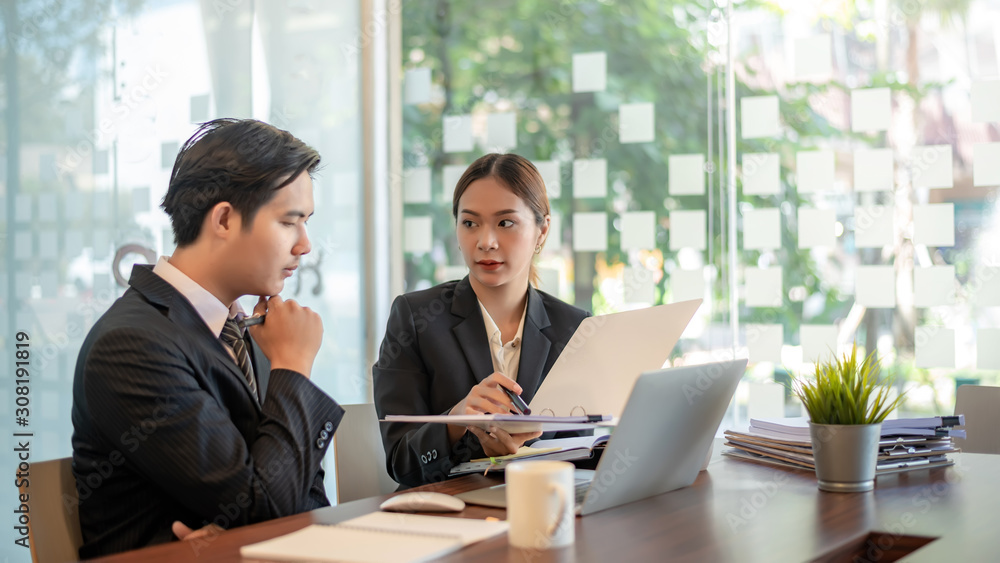 Modern business people discussing work in office and using laptop together while working. Modern business people discussing work in office and using laptop together while working.