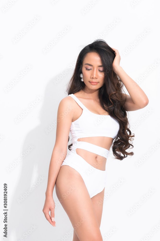 Beautiful asian woman black hair and long hair wearing a white swimsuit in posting standing summer fashion on isolated white background and shadow. Beautiful asian woman black hair and long hair wearing a white swimsuit in posting standing summer fashion on isolated white background and shadow.