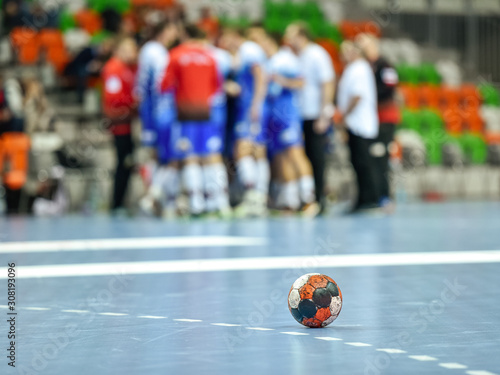 LUBIN, POLAND - DECEMBER 4, 2019: Polish PGNiG Superleague men handball match between MKS Zaglebie Lubin - MMTS Kwidzyn. Handball ball lying on the blue parquet .