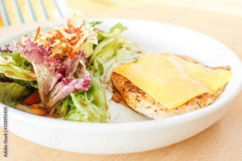 Grilled chicken steak with melted cheese and mixed salad