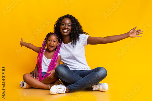 Photography Little afro girl sitting with mom and repeating her gestures