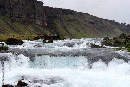 Mountain stream cold water running over rocks and stones. Iceland