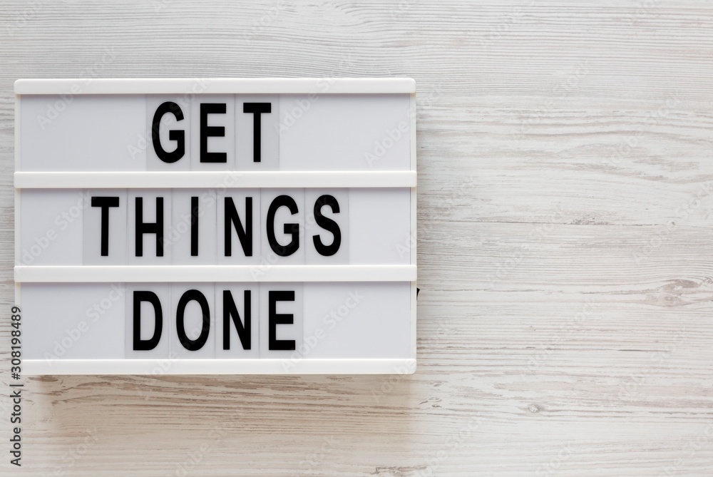 'Get things done' words on a lightbox on a white wooden surface, top view. Overhead, from above, flat lay. Space for text. 'Get things done' words on a lightbox on a white wooden surface, top view. Overhead, from above, flat lay. Space for text.