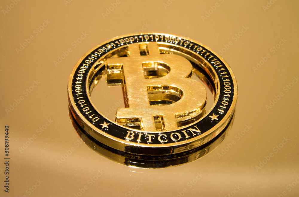 Golden coin bitcoin cryptocurrency on a mirrored surface