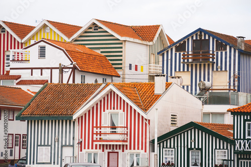 Facades of colorful striped houses in Costa Nova, Portugal. Pattern of village neare ocean 