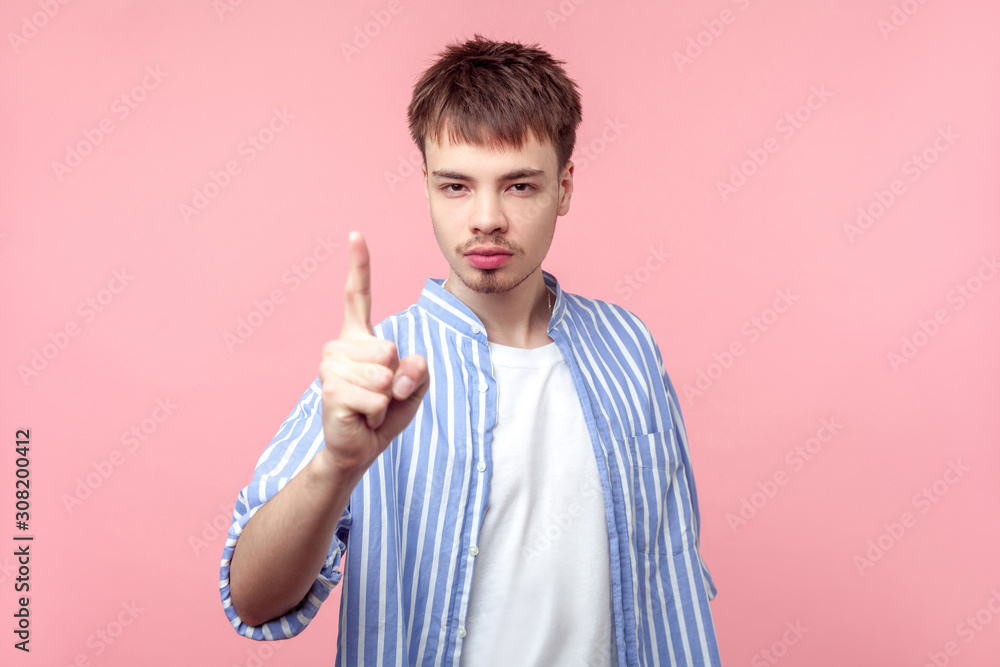 Be careful! Portrait of bossy brown-haired man with small beard and mustache in casual striped shirt looking at camera showing warning sign, caution. indoor studio shot isolated on pink background Be careful! Portrait of bossy brown-haired man with small beard and mustache in casual striped shirt looking at camera showing warning sign, caution. indoor studio shot isolated on pink background