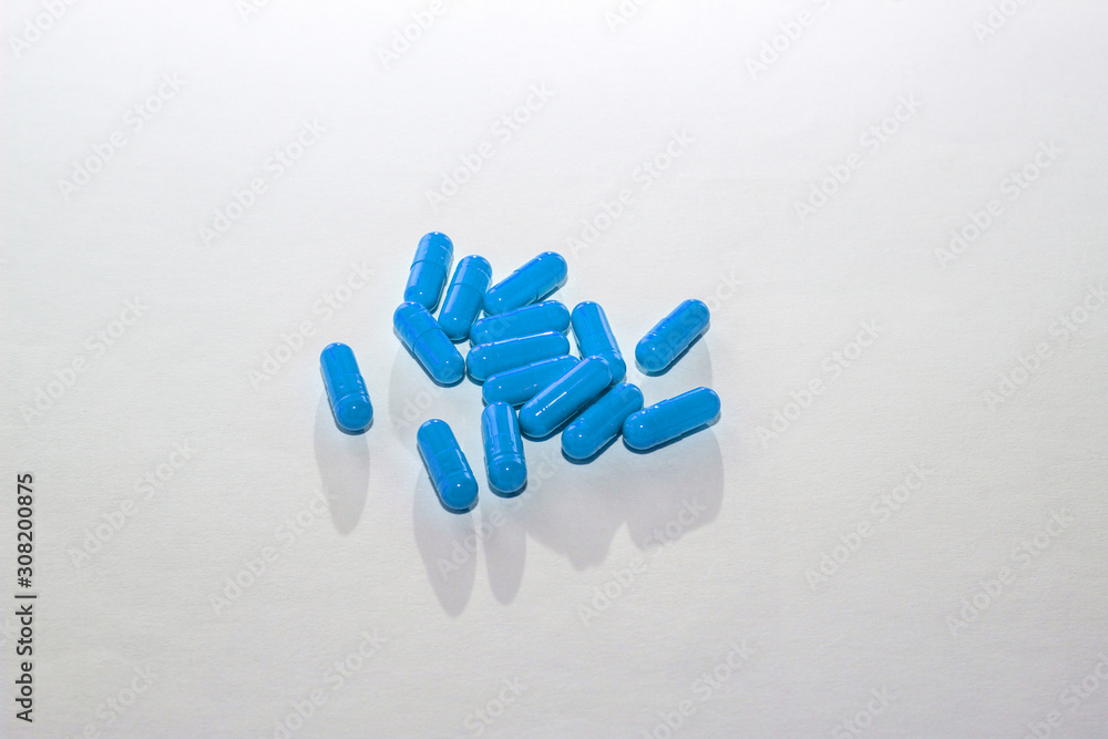 Scattered blue pills on white paper. Layout for special offers, advertising, web background. The concept of medicine, pharmacy, healthcare. Empty space for text, logo. Close-up, isolate of drugs Scattered blue pills on white paper. Layout for special offers, advertising, web background. The concept of medicine, pharmacy, healthcare. Empty space for text, logo. Close-up, isolate of drugs