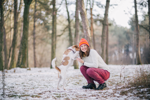 Fototapeta Naklejka Na Ścianę i Meble -  Woman playing with her dog outdoors. Fox terrier enjoying nature.