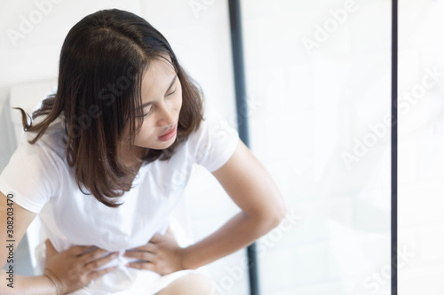 Close up woman stomachache with toilet in the morning, health care concept, selective focus