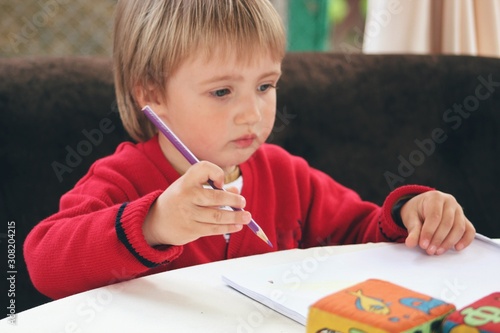 Obraz na płótnie Portrait of little caucasian boy in casual clothes studying at home w salonie