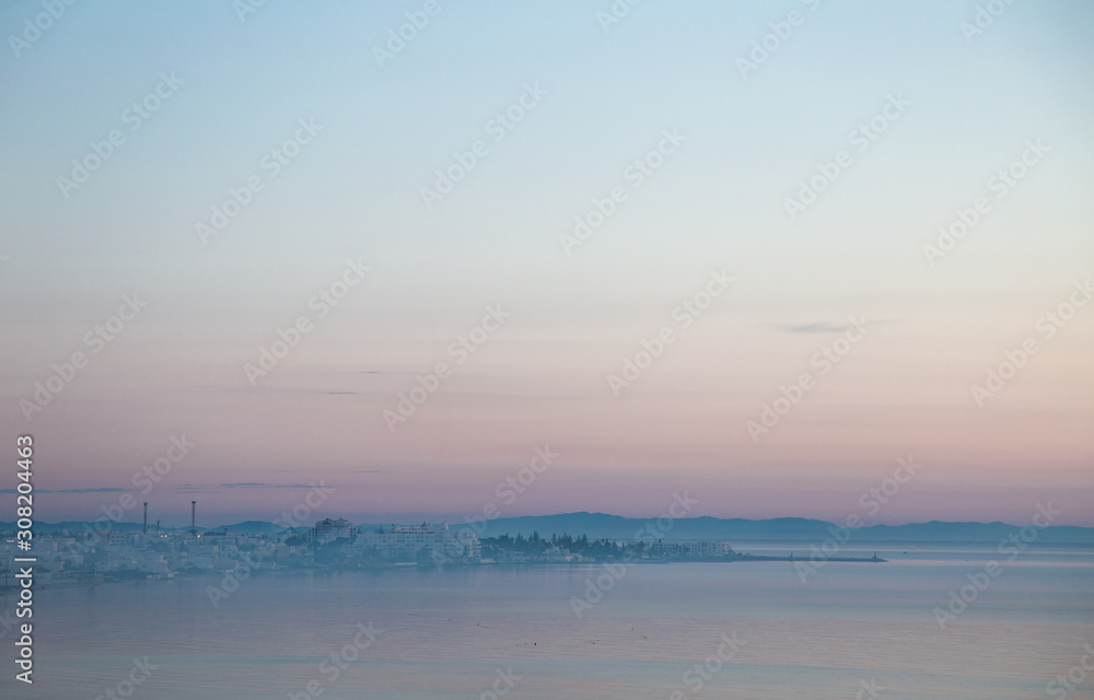 Early morning misty view of coastal line of Tunisian city El Kantaoui cityline. Horizontal color photography.