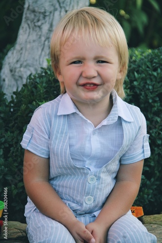 Obraz na płótnie Portrait of little caucasian boy in casual clothes in home garden w salonie