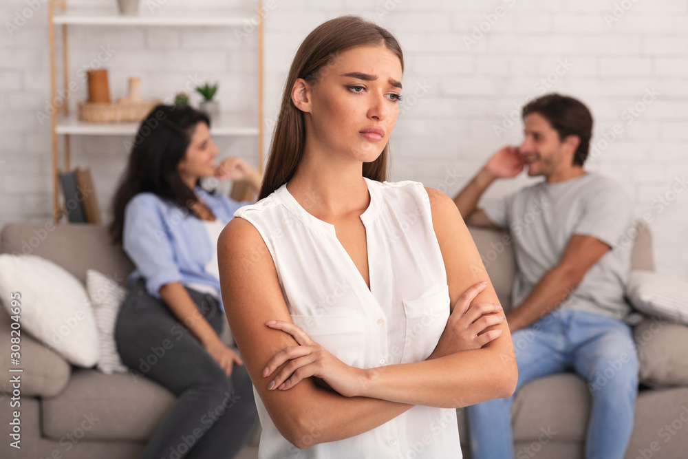Girlfriend Standing While Boyfriend Flirting With Girl Sitting On Sofa Girlfriend Standing While Boyfriend Flirting With Girl Sitting On Sofa