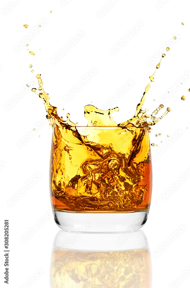 Whiskey glass with ice isolated on white background. Whisky splashes up from the glass. Whiskey glass with ice isolated on white background. Whisky splashes up from the glass.