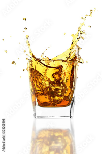 Whiskey glass with ice isolated on white background. Whisky splashes up from the glass.