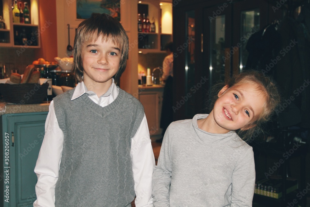 Portrait of little caucasian girl and boy in casual clothes hugging