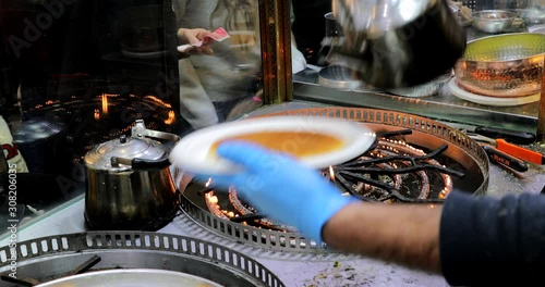 Chef at an oriental food stall in the market making Middle-Eastern Delicious traditional dessert kadayif kunefe with pistachios. Turkish dessert kadayif kunefe. photo