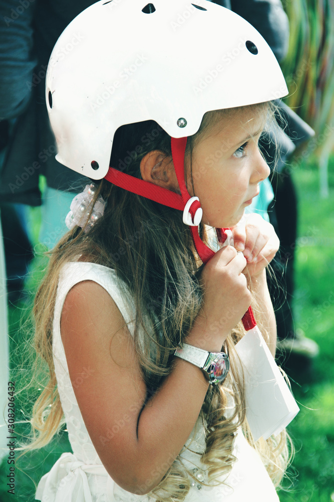 Portrait of little caucasian girl wearing sport helmet on the street