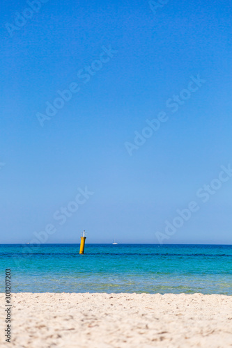 Beautiful marine landscape of soft peaceful waves of sea water  sunny clear blue sky. Vertical color photography.