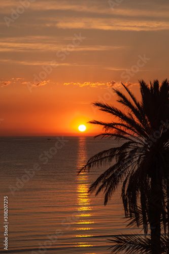 Beautiful sunny golden smooth texture of peaceful evening or morning sea water with charming romantic reflections of sun path on blurry surface of water. Natural vertical photo background. 