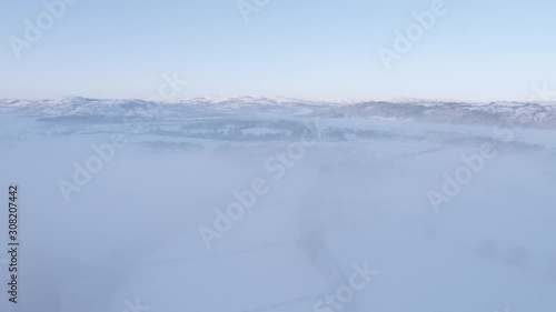 rise through mist above a village in the snow photo