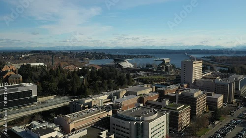 Aerial footage of the University of Washington with the surrounding commercial and residential area, dormitories and classroom buildings in the background photo
