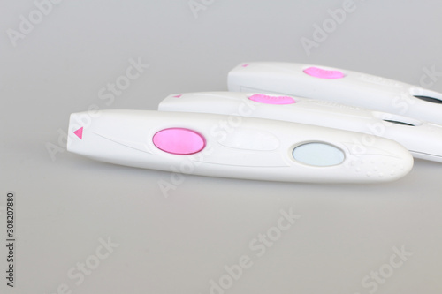 pregnancy test close-up with a big pink button on a gray background
