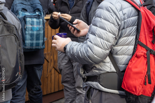 Touristen am Christkindlesmarkt Nürnberg mit Handy und Glühwein