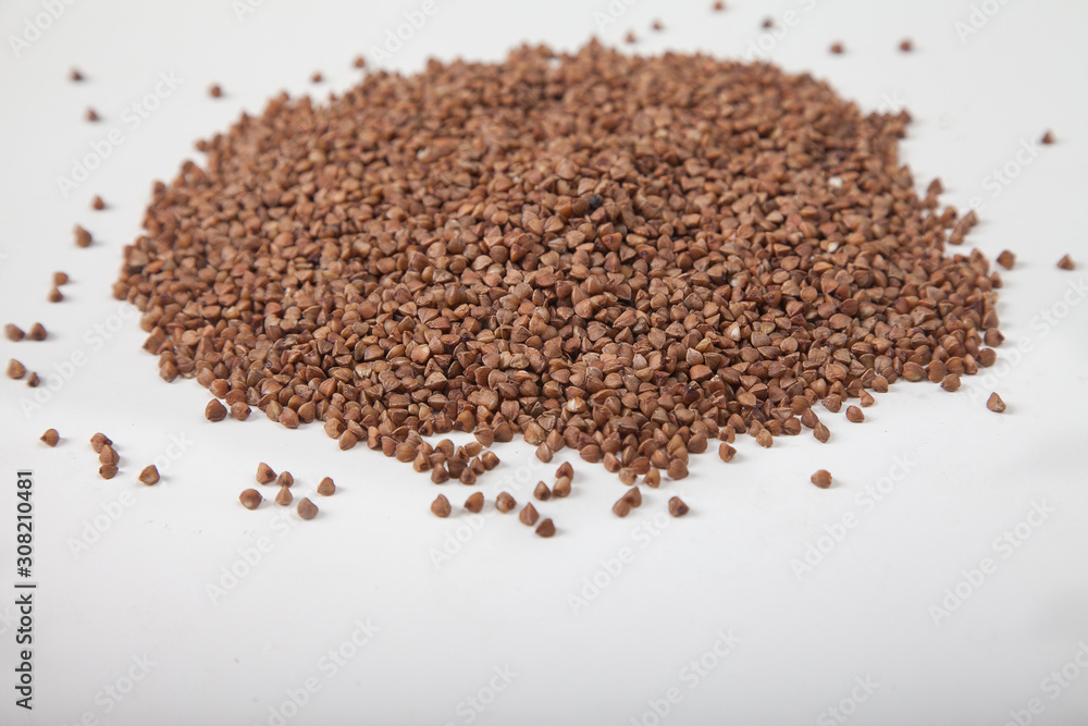 Buckwheat seeds closeup isolated on white background. Top view. Buckwheat seeds closeup isolated on white background. Top view.