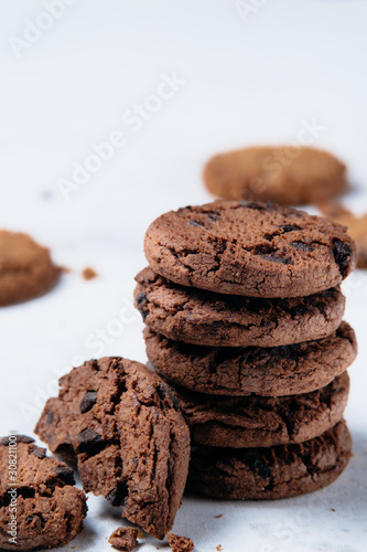 Stack of tasty chocolate chip cookies on white background.