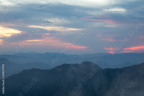Sunset or evening time over clouds with mountain hill forest and sunlight sunrays or sunbeams on background. at "LerGuaDa" Tak province, Thailand, Asia.