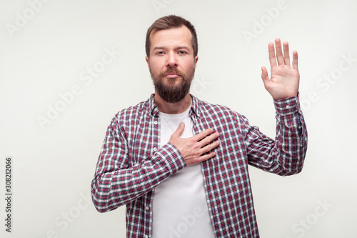 Foto I swear! Portrait of responsible bearded man in plaid shirt keeping hand on chest making promise, swearing to tell the truth, be honest dedicated