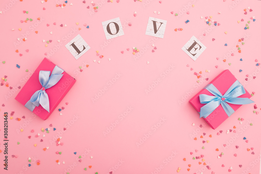 Valentines day composition with love inscription and gifts on pink background. Flat lay