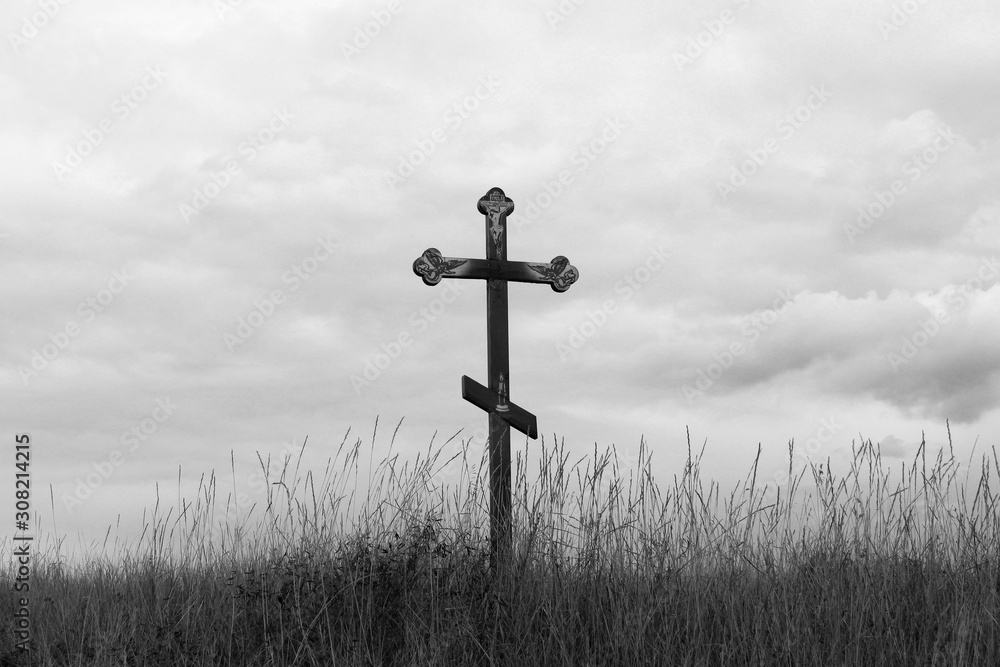 Black-and-white photo with wooden cross on sky background Black-and-white photo with wooden cross on sky background