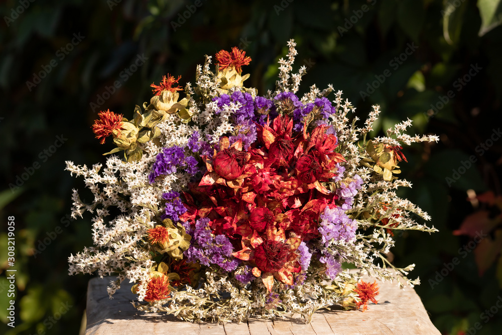 Autumn bouquet of dried flowers on a wooden board