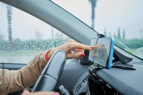 business woman in the car programming the browser on the smartphone, closeup