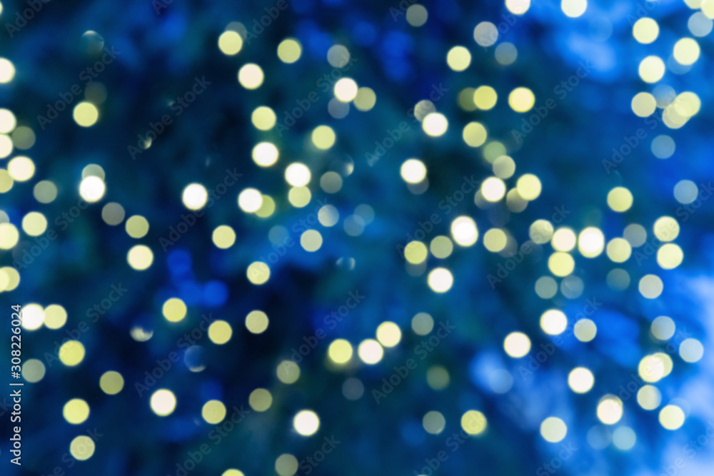 Bright bokeh texture on blue background. Defocused image of christmas decoration outdoors. 