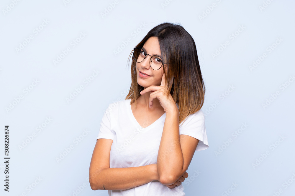 Young woman over isolated blue background with glasses Young woman over isolated blue background with glasses