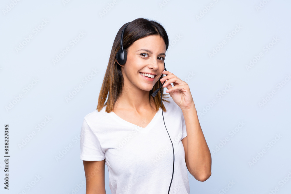 Young woman over isolated blue background working with headset Young woman over isolated blue background working with headset