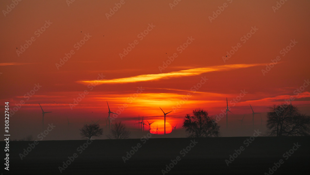 Windmühlen vor Sonnenball im Morgengrauen bei Wolkelosen Himmel