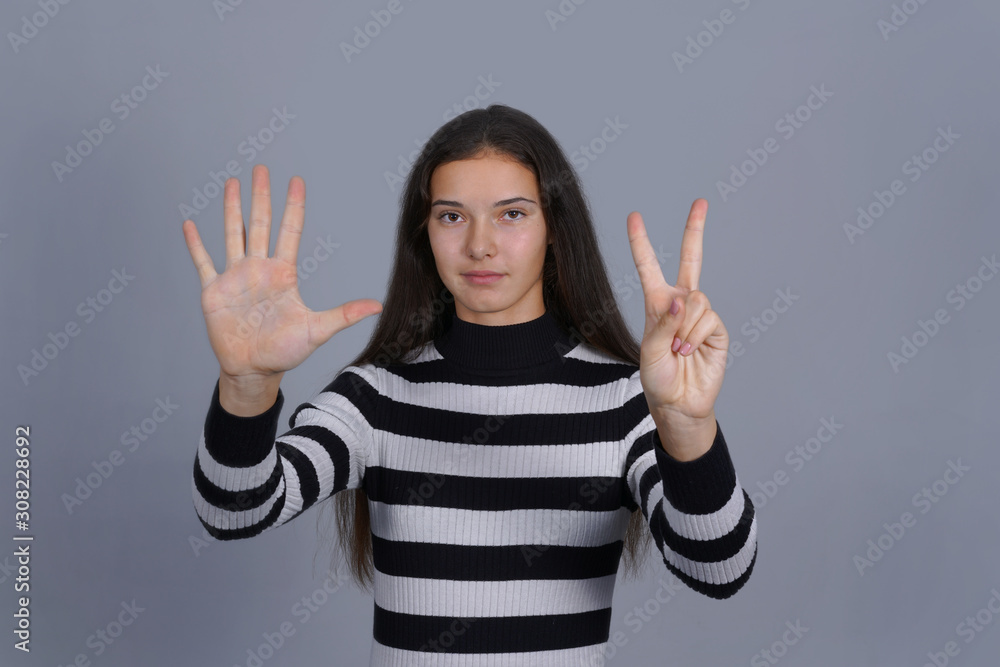 girl showing seven sign by hand isolated gray background girl showing seven sign by hand isolated gray background