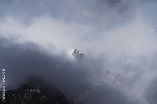 Snow mountain peak behind dark cloudy 