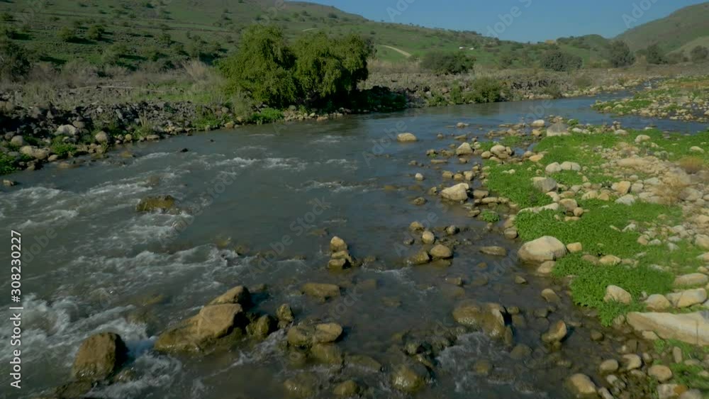 River Jordan water flows on a sunny day. Aerial flying over River Jordan water flows on a sunny day. Aerial flying over