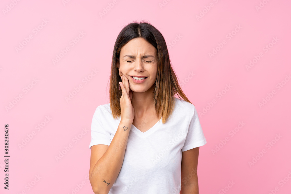 Young woman over isolated pink background with toothache Young woman over isolated pink background with toothache