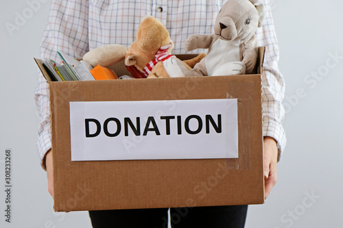 Wallpaper Mural Donation concept: woman holding box full of books and toys. Donate for children please Torontodigital.ca