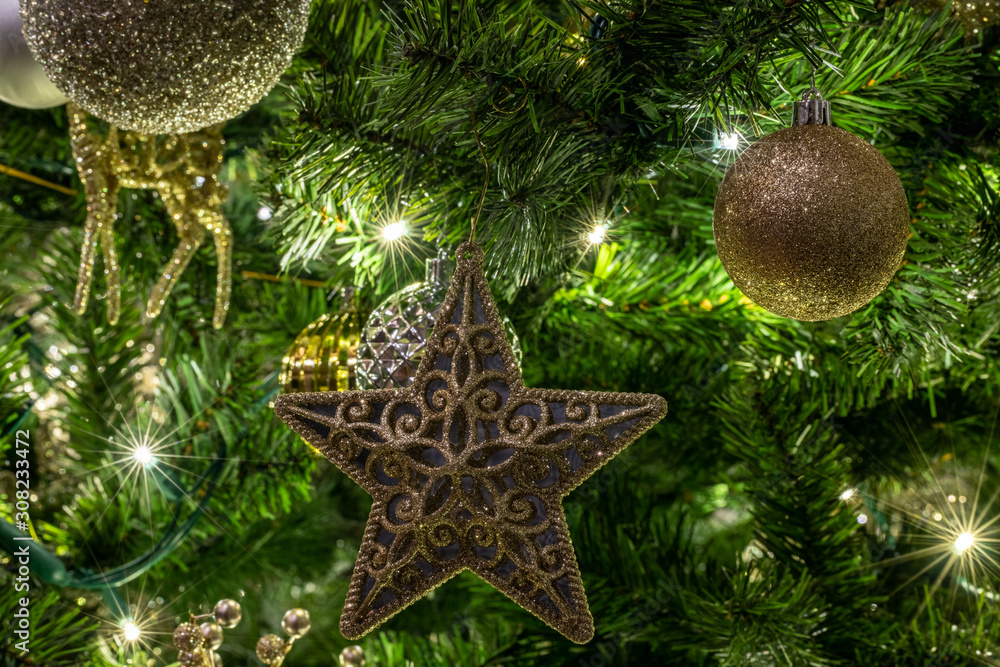 Details of a Christmas tree with tree branches hung with ball and ...