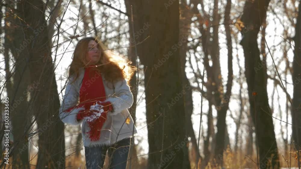 girl in winter forest playing with snow and smiling girl in winter forest playing with snow and smiling