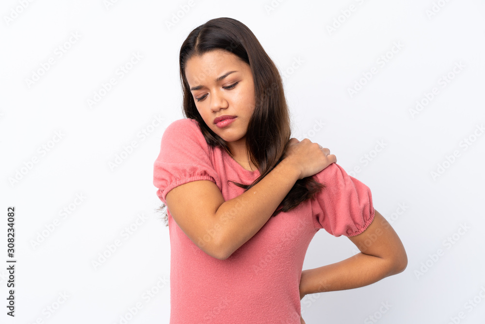 Young Colombian girl over isolated white background suffering from pain in shoulder for having made an effort Young Colombian girl over isolated white background suffering from pain in shoulder for having made an effort