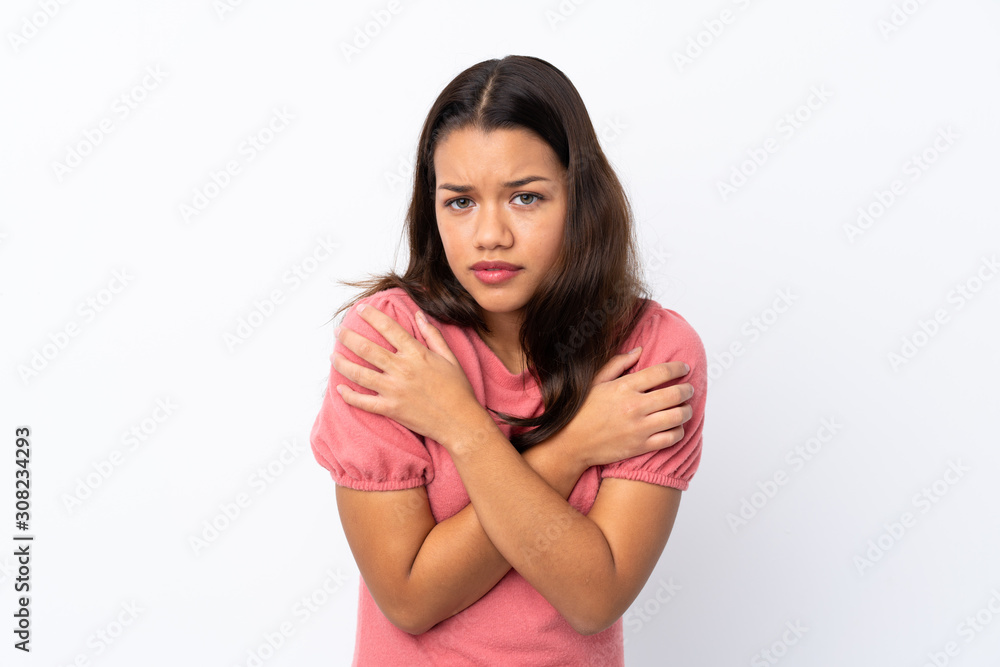 Young Colombian girl over isolated white background freezing Young Colombian girl over isolated white background freezing