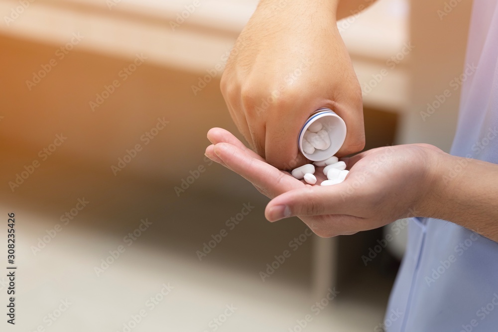 A patient take some white pills on hand for treatment